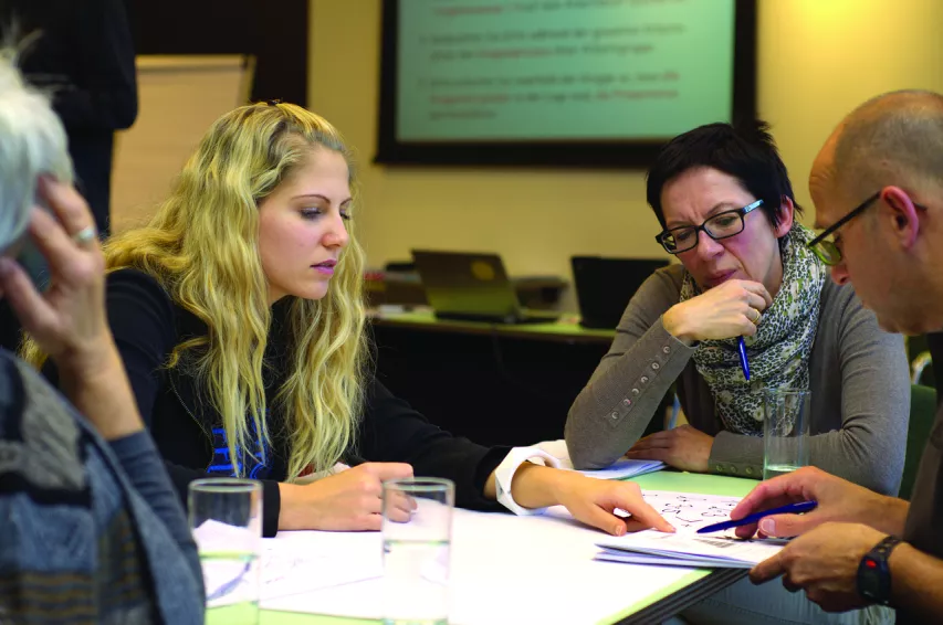 Quatre personnes sont autour d'une table dans le cadre d'une réunion de travail